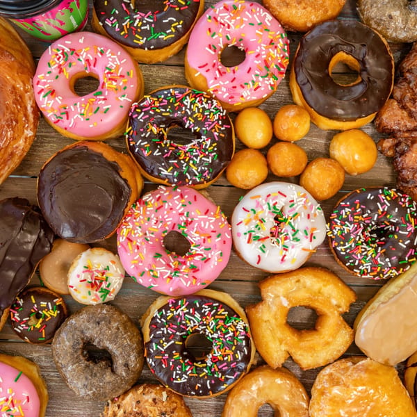 An overhead shot of various Dank Donuts, including frosted, sprinkled, glazed, and donut holes.