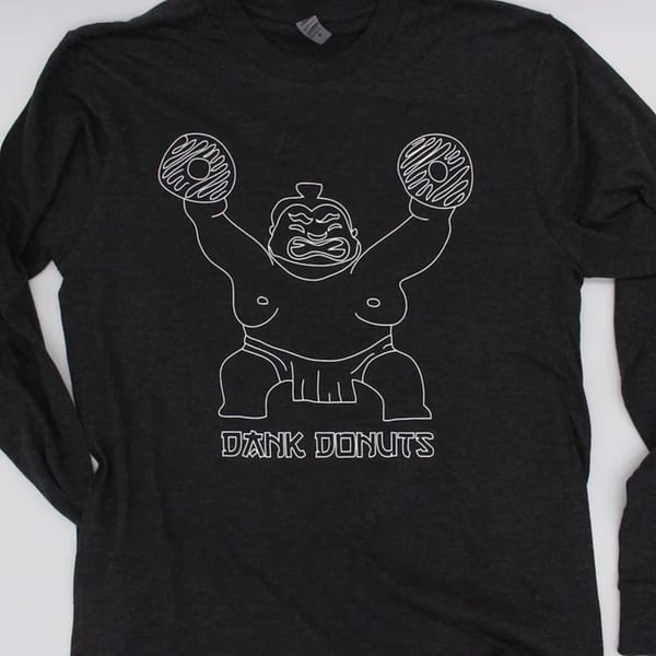 Black long-sleeved shirt with a white outline of a sumo wrestler holding two donuts.